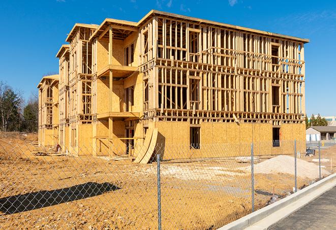 workers protected by temporary barrier fence during building maintenance in Cudahy